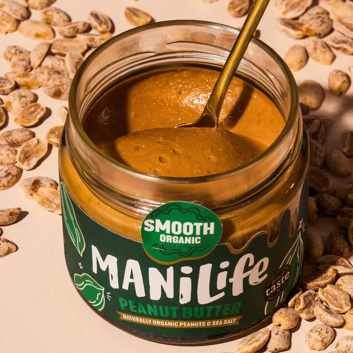 An open jar of ManiLife smooth organic peanut butter